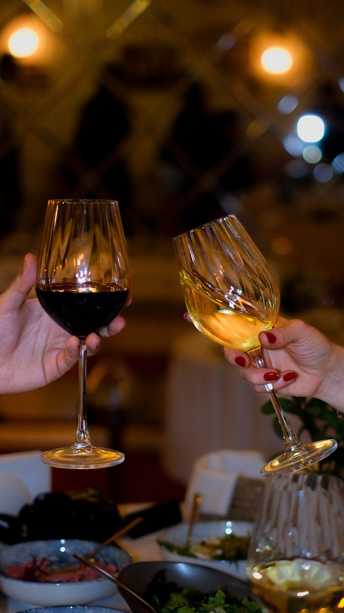 Celebratory toast with red and white wine in a cozy, elegant setting, perfect for special occasions.